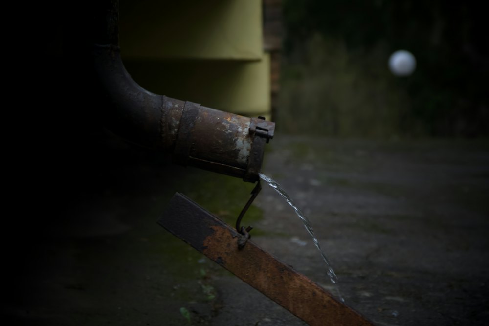 Agua goteando por una bajante deteriorada